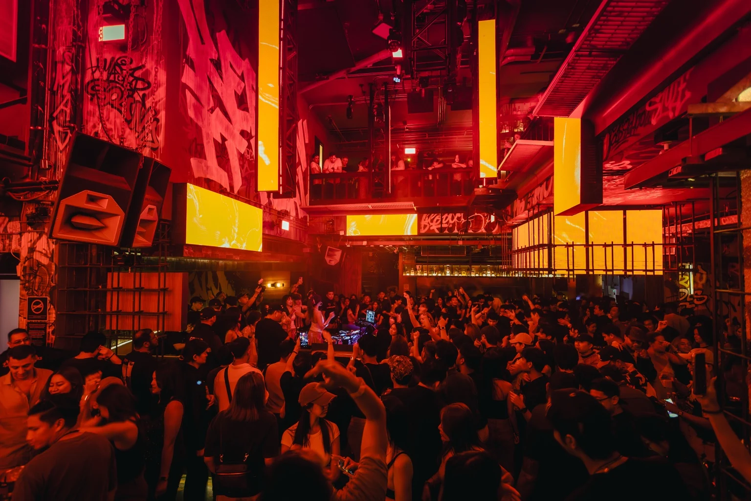 Crowd under red and amber lights in the main room