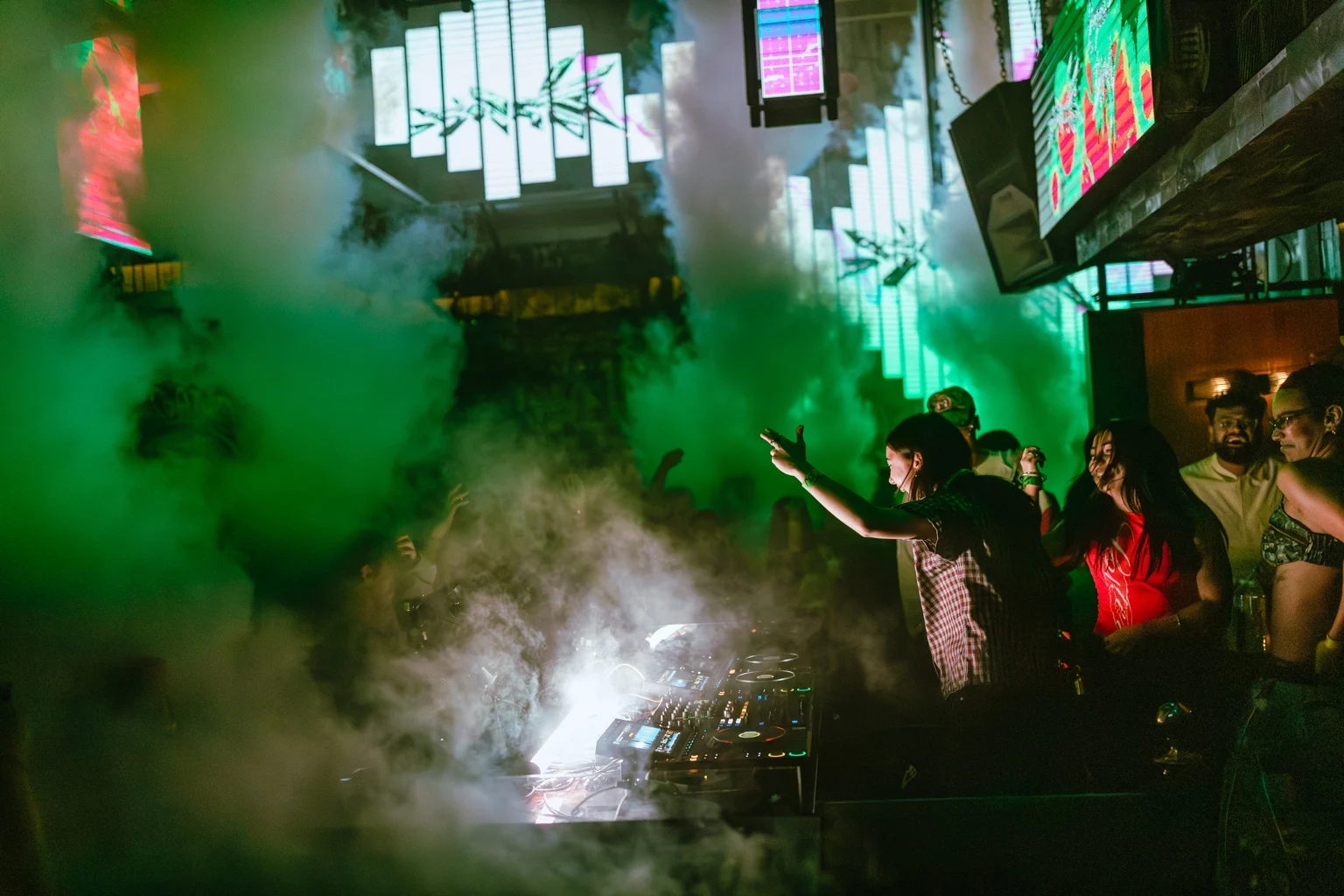 Green lighting and smoke near the DJ booth